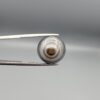 Multi-angle macro photographs of a 12.87-carat natural African Banded Eye Agate (Sulemani Aqeeq) held in gem tweezers, displaying a high round cabochon dome with concentric white and grey fortification rings, a brownish-black core pupil, and a base showing soft blue-grey to dark gradient chalcedony.