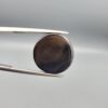 Multi-angle macro photographs of a 12.76-carat natural African Banded Eye Agate (Sulemani Aqeeq) held in gem tweezers, displaying a high round cabochon dome with concentric white and dark brown fortification rings framing a defined eye motif, tiered side profile banding, and a smooth dark brown base.