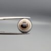 Multi-angle macro photographs of a 5.64-carat natural African Banded Eye Agate (Sulemani Aqeeq) held in gem tweezers, displaying a high round cabochon dome with precise concentric white and warm brown fortification rings around a dark brown core, crisp side profile banding, and a reverse side showing a unique tricolor blue, white, and dark brown pattern.