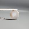 Multi-angle macro photographs of a 10.43-carat natural African Banded Eye Agate (Sulemani Aqeeq) held in gem tweezers, displaying a high round cabochon dome with translucent smoky-white mist halo eye banding, flank-textured fortification rings along the side profile, and a flat translucent base with a bright focal spot center.