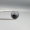 Multi-angle macro photographs of a 6.67-carat natural African Banded Eye Agate (Sulemani Aqeeq) held in gem tweezers, showing a high round cabochon dome with a deep onyx-black body framed by a sharp, concentric white outer arc, smooth profile curvature, and a polished solid black reverse base.