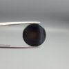 Multi-angle macro photographs of a 13.29-carat natural African Banded Eye Agate (Sulemani Aqeeq) shown in gem tweezers and held on a finger, featuring a high round cabochon dome with a deep charcoal body, subtle translucent inner zoning, layered side fortification bands, and a smooth black base.