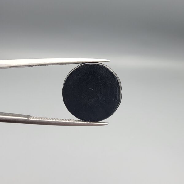 Macro photographs of an 11.69-carat natural African Banded Eye Agate (Sulemani Aqeeq) held in steel gem tweezers, displaying a high round cabochon dome with a deep onyx-black body centered by a luminous blue-grey eye motif, and a polished flat black base.