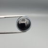 Multi-angle macro photographs of a 12.13-carat natural African Banded Eye Agate (Sulemani Aqeeq) held in steel gem tweezers, showcasing a top view with a mirror-polished deep black body bordered by a fine white ring, a side profile displaying lower white flank banding, and a reverse view revealing a unique luminous blue-grey eye motif on a flat black field.