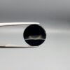 Multi-angle macro photographs of a 7.64-carat natural African Banded Eye Agate (Sulemani Aqeeq) held in steel gem tweezers, showcasing a top view with a sharp concentric ring and lower translucent band, a side profile displaying smooth high-dome geometry with horizontal flank fortification, and a reverse view of a flat black base featuring a striking horizontal banded division.