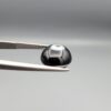 Multi-angle macro photographs of a 5.62-carat natural African Banded Eye Agate (Sulemani Aqeeq) held in steel gem tweezers, showcasing a top view with a central brown pupil core encircled by a white halo ring set within a deep black body, a side profile displaying smooth high-dome geometry with lower flank fortification, and a reverse view revealing a flat translucent milky-blue base with a solid black eclipse patch.