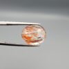 High-resolution macro photographs of an 8.52-carat natural Rutilated Quartz (Moh-e-Najaf) held in steel tweezers, showcasing a brilliant oval facet cut, exceptional crystal clarity, and a dynamic internal weave of coppery orange-red hematite platelets interspersed with fine rutile needles sourced from Najaf Al-Ashraf, Iraq.