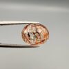 High-resolution macro photographs of a 7.20-carat natural Rutilated Quartz (Moh-e-Najaf) held in steel tweezers, displaying a brilliant oval facet cut, water-clear crystal clarity, and a dramatic internal network of crisscrossing copper-red blades with contrasting dark rutile needles sourced from Najaf Al-Ashraf, Iraq.