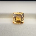 High-resolution macro photographs showing a 4.22-carat natural Citrine Quartz (Sunela) octagon step cut gemstone displayed in a luxury white-padded display box, exhibiting luminous golden-yellow saturation, eye-clean clarity, and crisp step-cut facets.