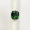 High-resolution scan of an official GGI (Galaxy Gemological Institute) Gemstone Report for a 1.48-carat Natural Chrome Green Tourmaline sourced from Tanzania, detailed with certificate number KHI2610280448, cushion mixed cut dimensions (7.77 x 6.94 x 4.33 mm), transparent green color, and QR verification code.
