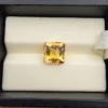 High-resolution macro photographs showing a 4.22-carat natural Citrine Quartz (Sunela) octagon step cut gemstone displayed in a luxury white-padded display box, exhibiting luminous golden-yellow saturation, eye-clean clarity, and crisp step-cut facets.