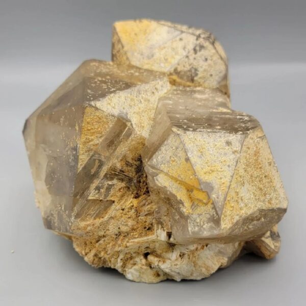 High-resolution macro photographs showcasing a monumental 2,318-gram natural Smoky Quartz multi-crystal cluster specimen from Pakistan, featuring fully formed translucent smoke-tea quartz prisms with sharp pyramidal terminations, natural earthy mineral coatings, and white feldspar matrix accents.