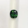High-resolution scan of an official GGI (Galaxy Gemological Institute) Gemstone Report for a 1.48-carat Natural Chrome Green Tourmaline sourced from Tanzania, detailed with certificate number KHI2610280448, cushion mixed cut dimensions (7.77 x 6.94 x 4.33 mm), transparent green color, and QR verification code.