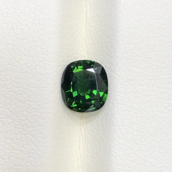 High-resolution scan of an official GGI (Galaxy Gemological Institute) Gemstone Report for a 1.48-carat Natural Chrome Green Tourmaline sourced from Tanzania, detailed with certificate number KHI2610280448, cushion mixed cut dimensions (7.77 x 6.94 x 4.33 mm), transparent green color, and QR verification code.